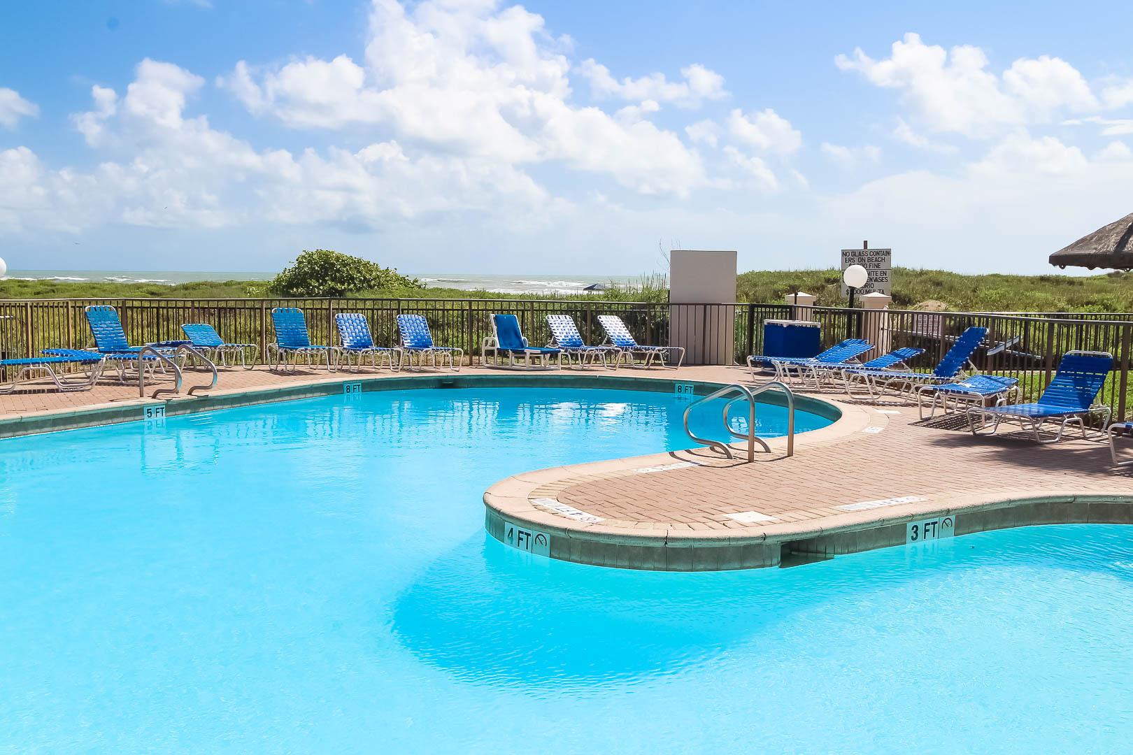 A refreshing beachfront outdoor swimming pool at VRI's Royale Beach and Tennis Club.